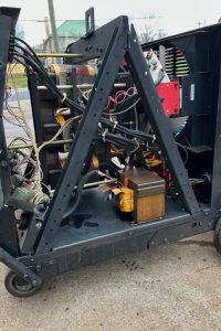 4a - Dupont Welder Services Industrial electrical equipment on a wheeled steel frame with tangled cables and a rusty transformer at the base.