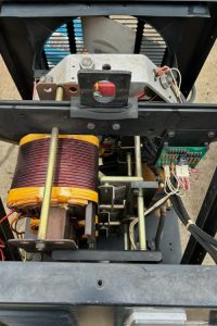 After Steam Cleaning - Dupont Welder Services Open view of a vintage power transformer and mechanical assembly with a large copper coil, metal frame, and wiring.