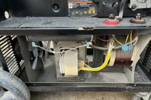 6b - Dupont Welder Services Industrial generator components: coils, transformers, and wiring visible inside the housing with a cooling fan nearby.