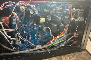 Multimatic after - Dupont Welder Services Internal view of a blue circuit board with capacitors, wires, and a transformer inside an electronic device chassis.