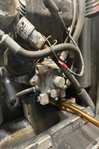 Close-up of a gas furnace gas valve and regulator with hoses, wires, and a copper gas line connection.